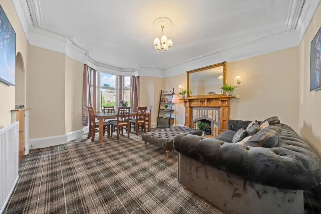 a living room with a couch and a fireplace at mySTAYINN Cedar Villa 9 Bedroom House - Inverness in Inverness