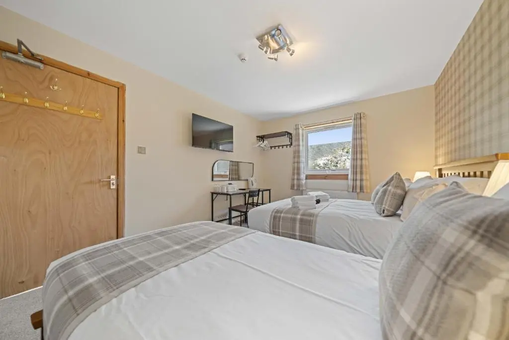 a bedroom with two beds and a window at mySTAYINN Cedar Villa Guest House in Inverness