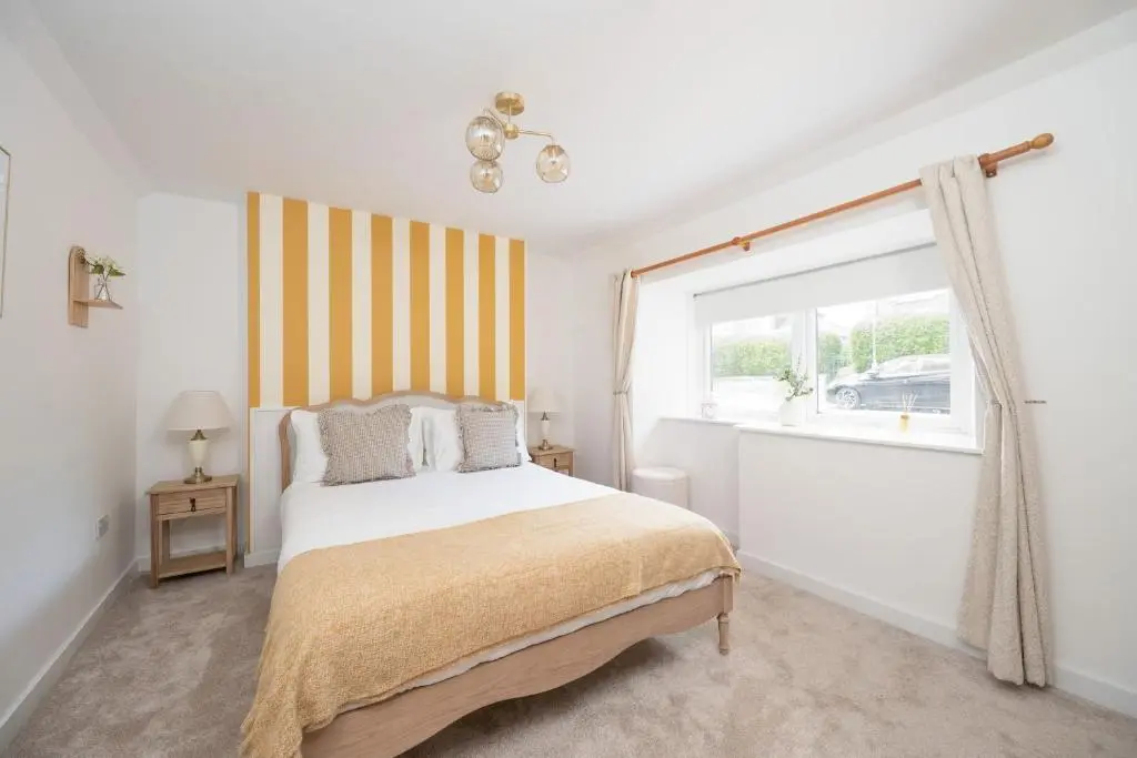 a bedroom with a bed and a window at Hideaway Cottage W Hot Tub in Portsoy