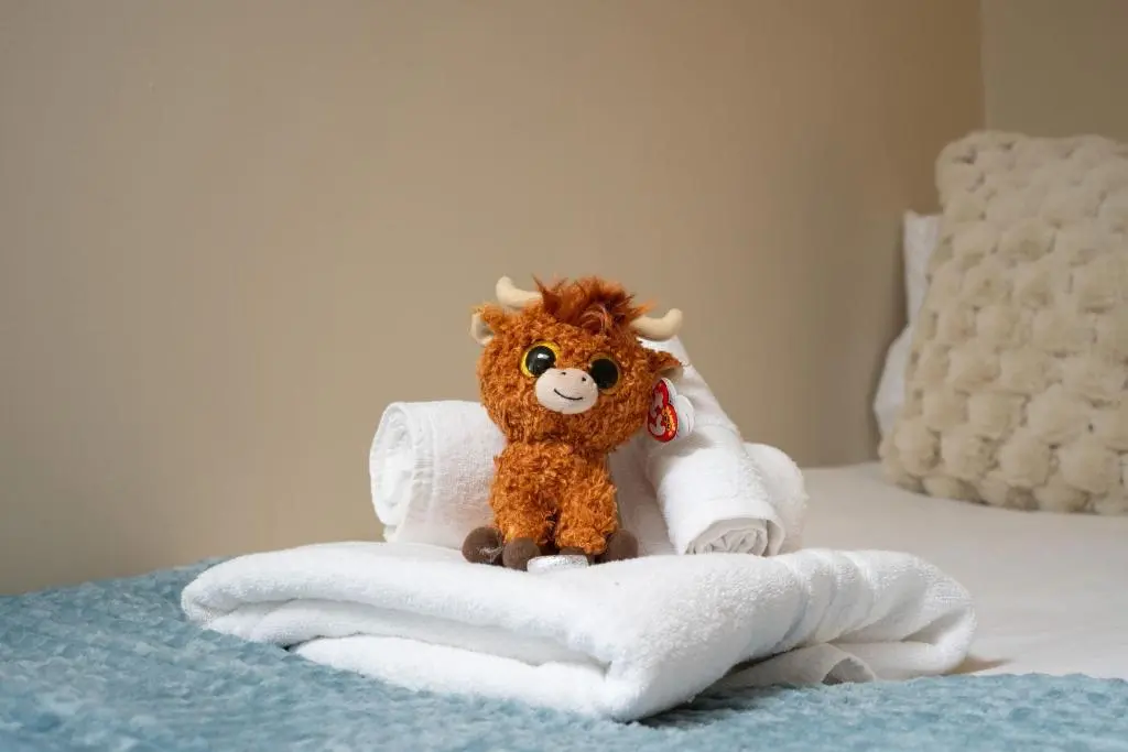 a stuffed animal sitting on a pile of towels at The Garden Cottage with Hot Tub in Portsoy