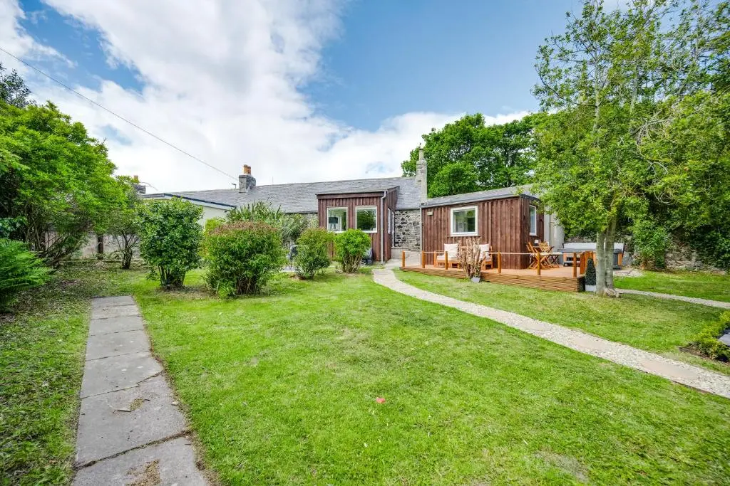 a home with a yard with a house at The Garden Cottage with Hot Tub in Portsoy