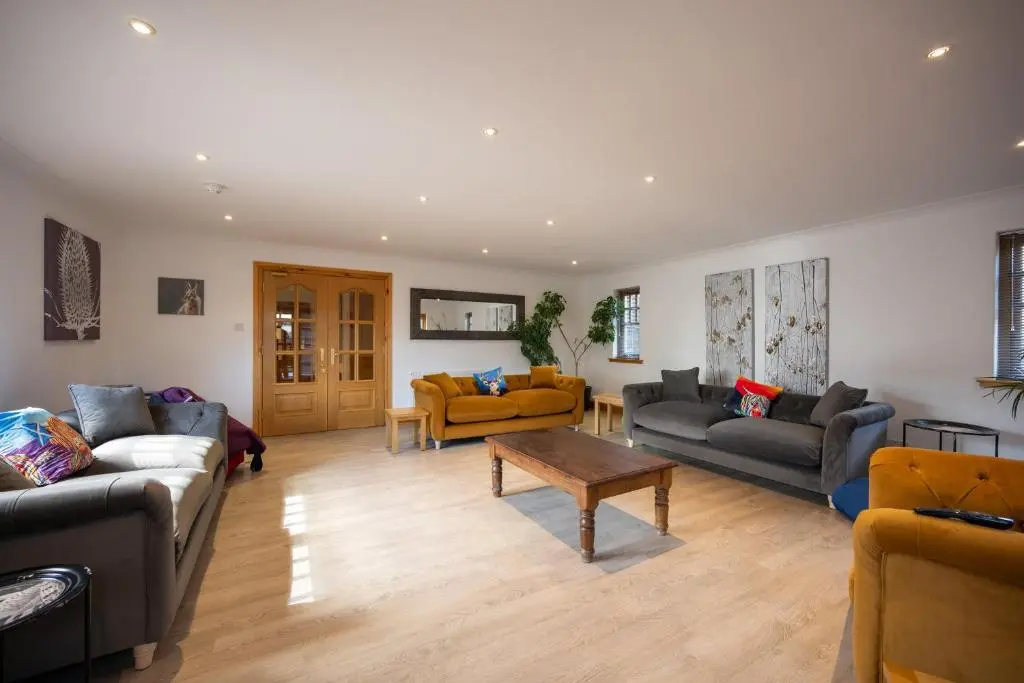 a living room with couches and a coffee table at Old Distillery Lodge in Kingussie