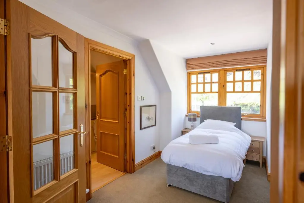a bedroom with a bed and a window at Old Distillery Lodge in Kingussie