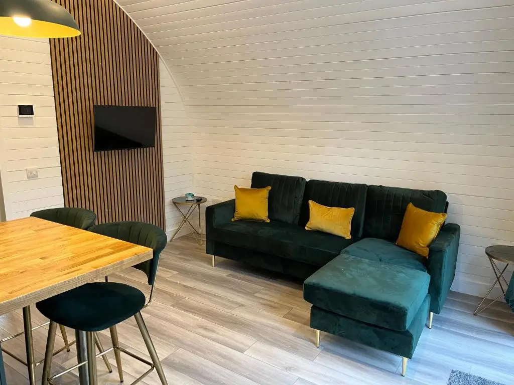 a living room with a couch and a table at Rosevalley luxury Glamping grouse pods in Cawdor