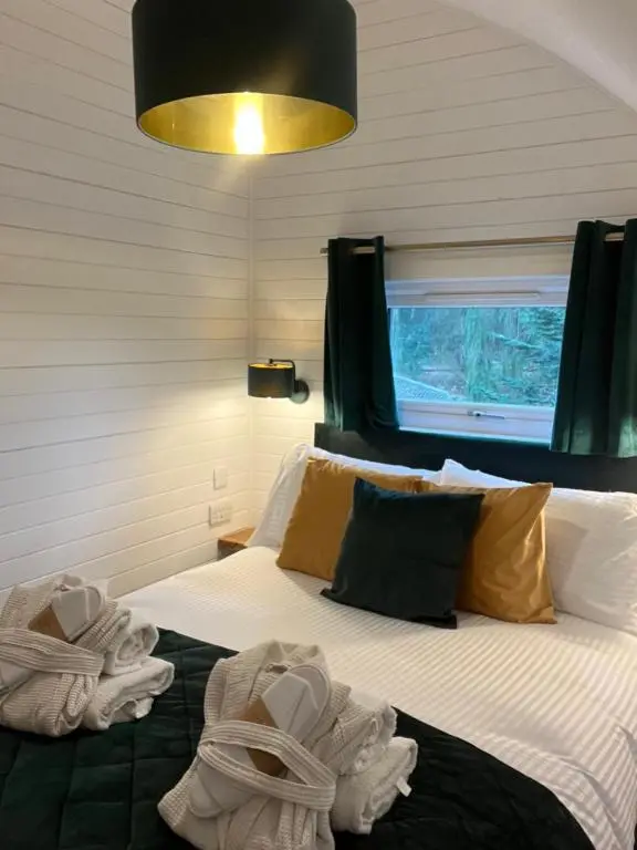 a bedroom with towels on a bed with a window at Rosevalley luxury Glamping grouse pods in Cawdor