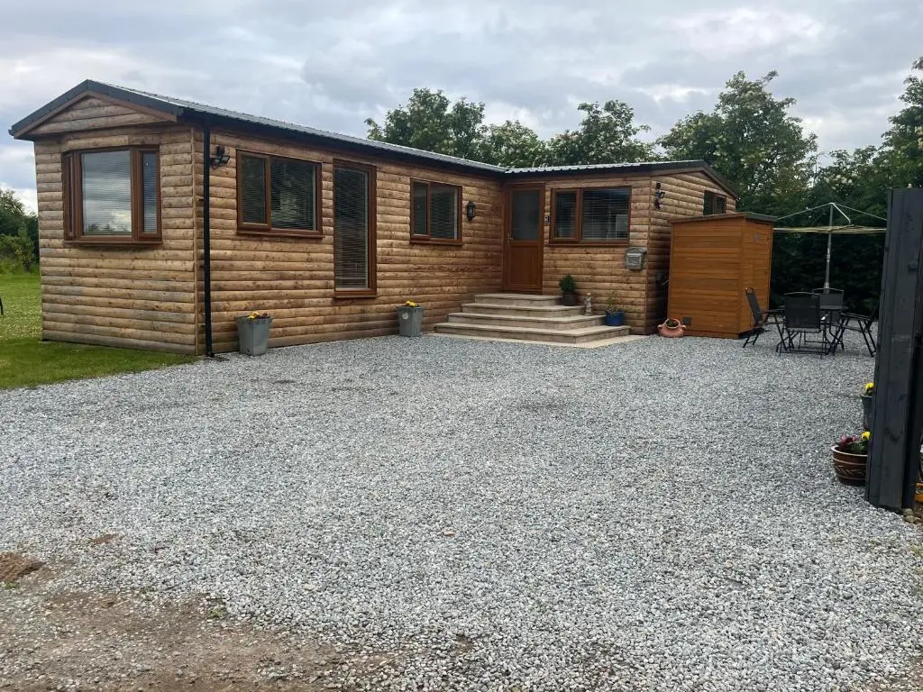 a log cabin with a gravel driveway at Fairview Workers Accommodation in Elgin