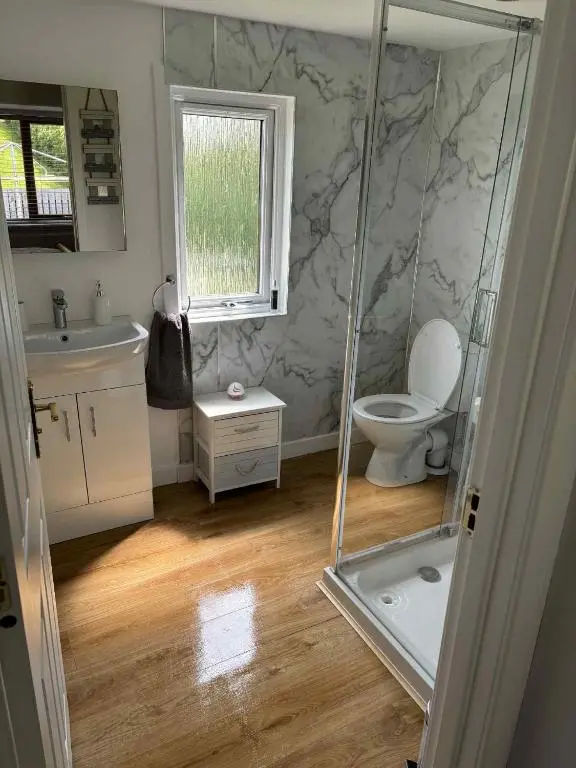 a bathroom with a shower and a toilet and a window at Fairview Workers Accommodation in Elgin