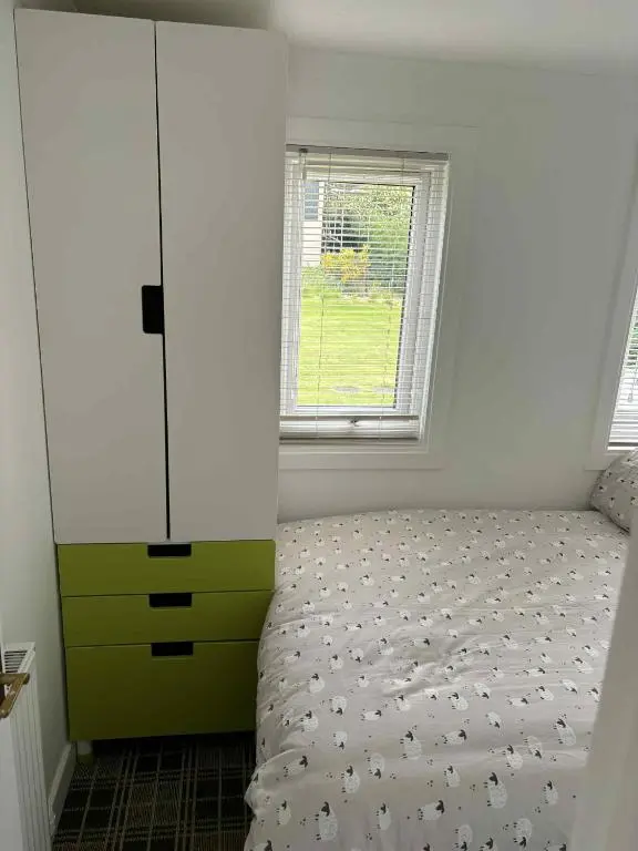 a bedroom with a bed and a dresser and a window at Fairview Workers Accommodation in Elgin