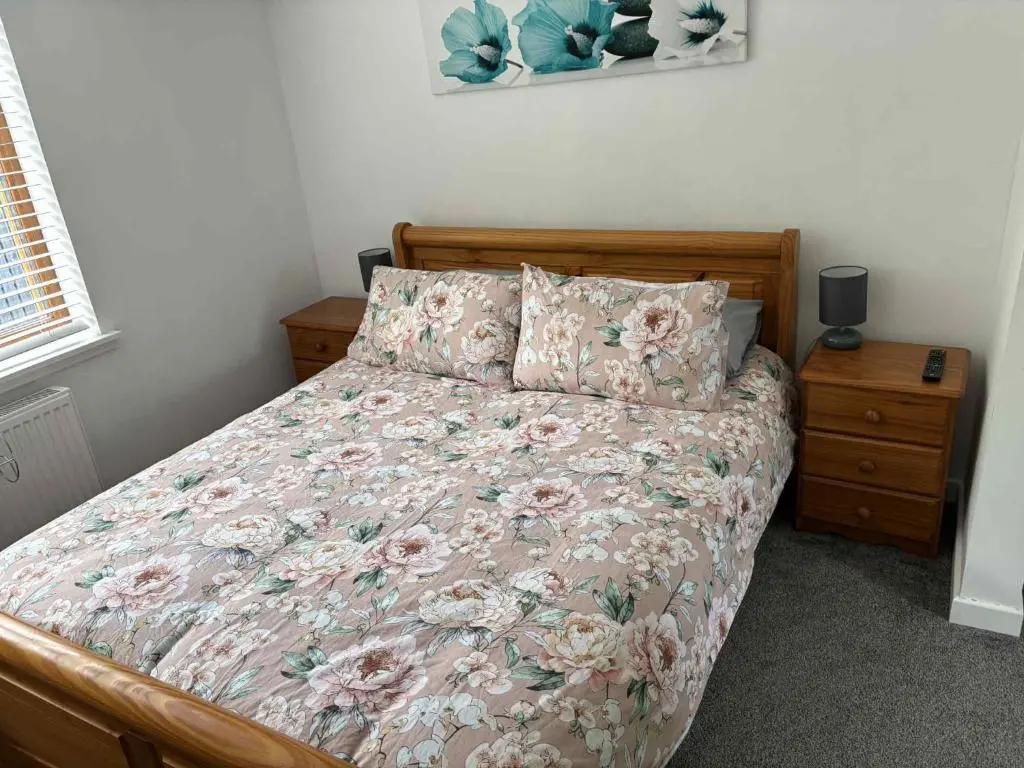 a bed with a floral comforter and two pillows at Fairview Workers Accommodation in Elgin
