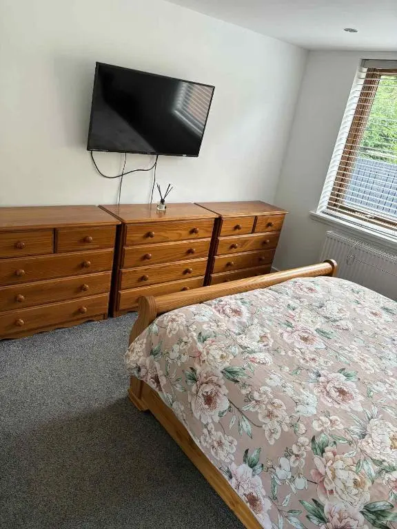 a bedroom with a bed and a dresser with a television at Fairview Workers Accommodation in Elgin