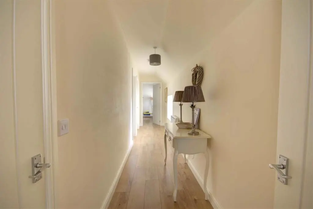 a hallway with a desk and a lamp on a table at Tweed Apartment, Golspie in Golspie