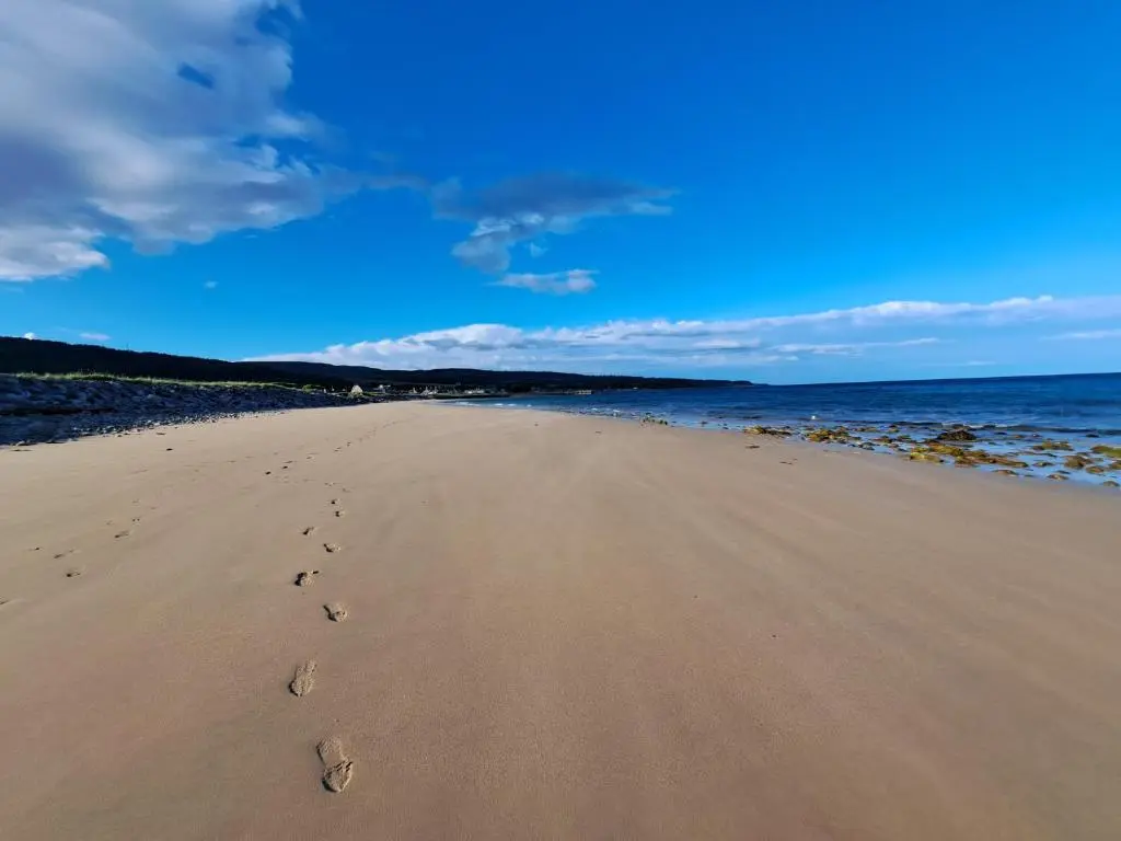 a pair of footprints in the sand on a beach at Tweed Apartment, Golspie in Golspie