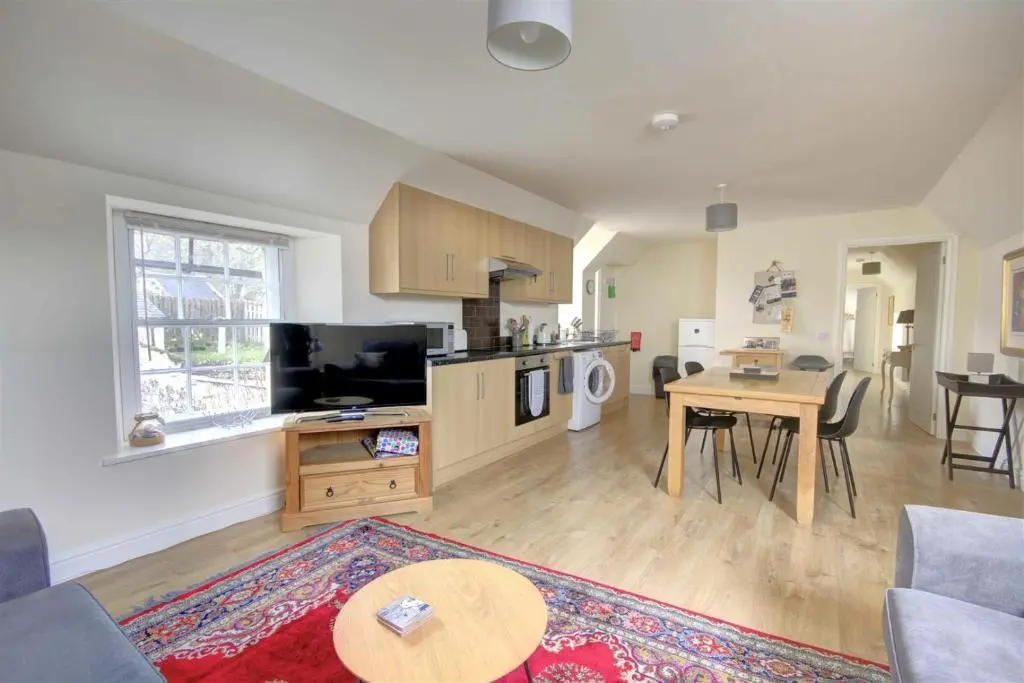 a living room with a kitchen and a dining room at Tweed Apartment, Golspie in Golspie