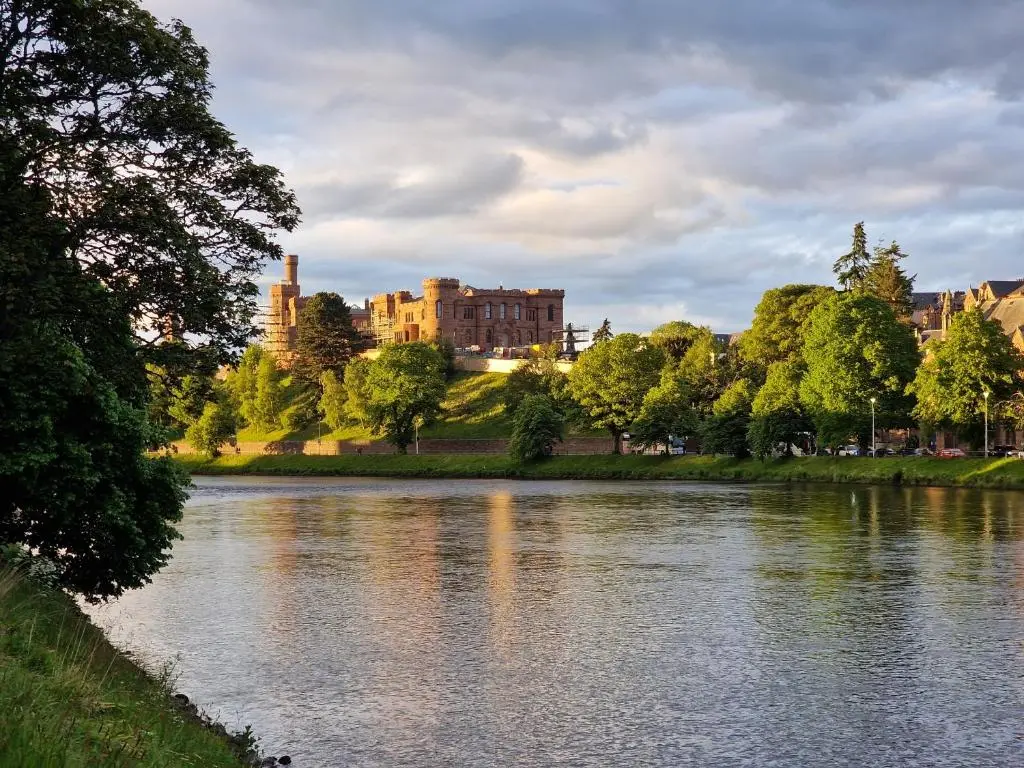 a view of a river with a building in the background at Failte Stay in Inverness