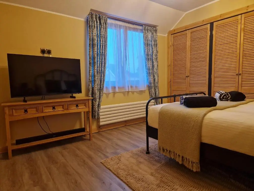 a bedroom with two beds and a flat screen tv at Failte Stay in Inverness