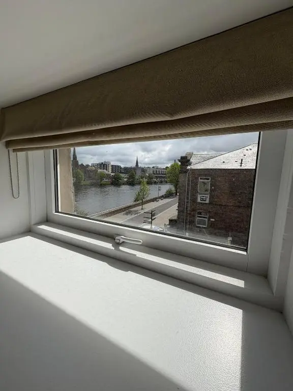 a window with a view of a river and buildings at River-View Loft, sleeps 4, with parking in Inverness