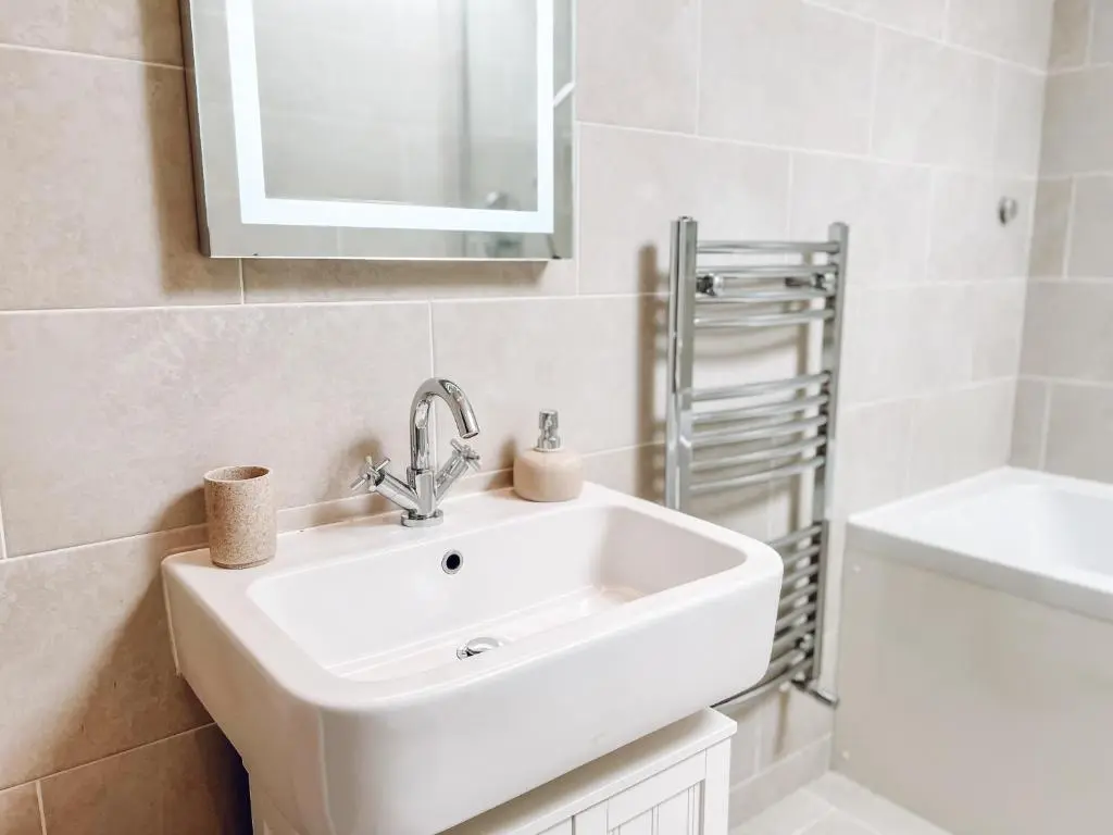 a white bathroom with a sink and a mirror at River-View Loft, sleeps 4, with parking in Inverness