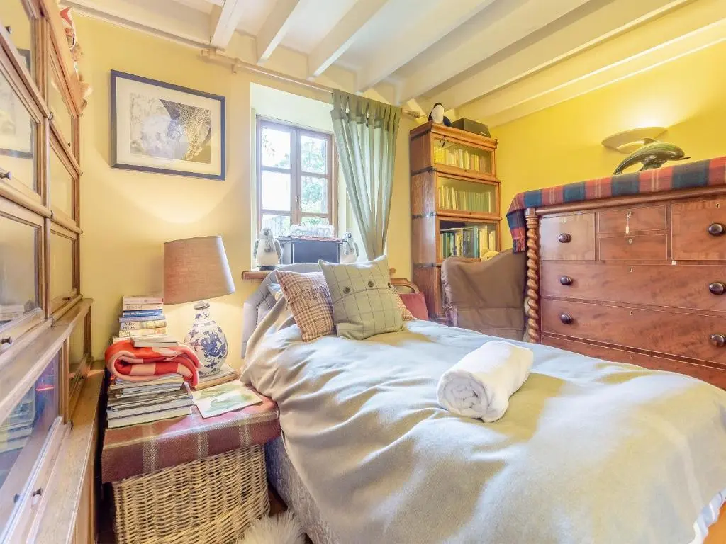 a bedroom with a large bed with a dresser and a dresser at Little Tarbet in Dornoch