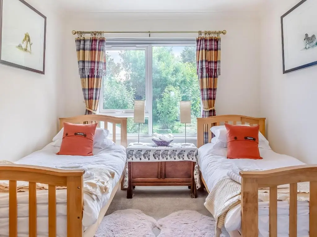 two twin beds in a room with a window at Highland Sanctuary in Dornoch