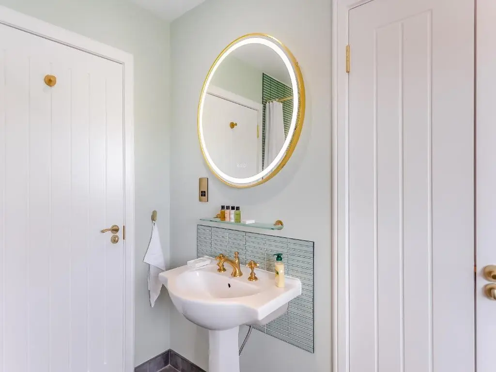 a white bathroom with a sink and a mirror at Highland Sanctuary in Dornoch
