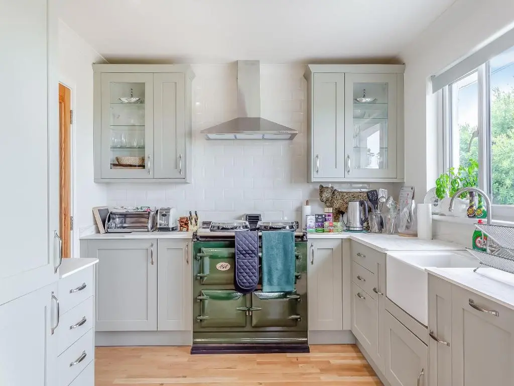 a kitchen with white cabinets and a green oven at Highland Sanctuary in Dornoch
