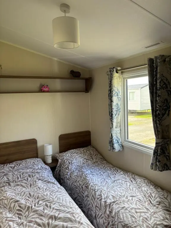 a bedroom with two beds next to a window at Sandy Shores in Embo