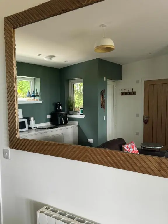 a mirror reflection of a kitchen and a living room at Wellhouse Country Lodges and Hot Tubs in Tore