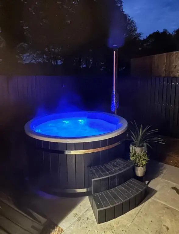 a hot tub in a backyard at night at Wellhouse Country Lodges and Hot Tubs in Tore