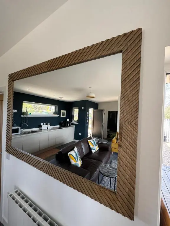 a living room with a large mirror on the wall at Wellhouse Country Lodges and Hot Tubs in Tore