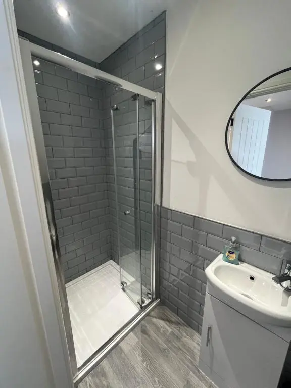a bathroom with a shower and a toilet and a sink at Fairfield Cottage Rooms in Inverness