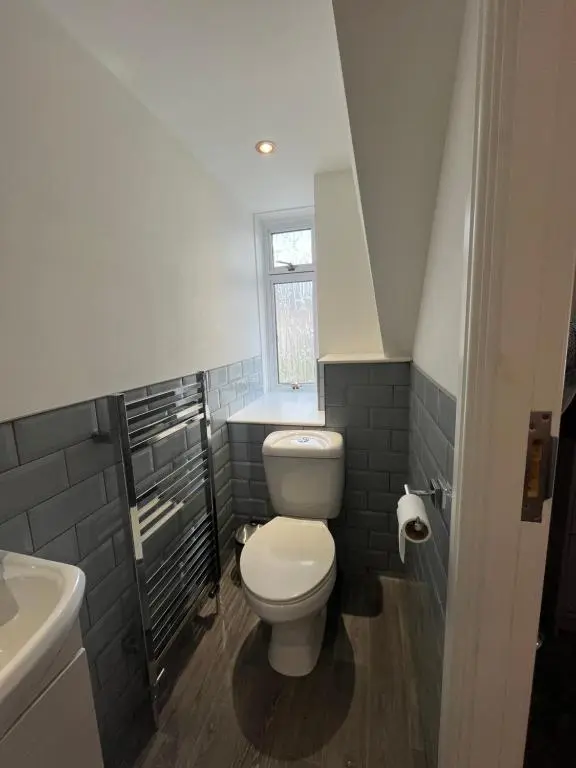 a bathroom with a white toilet and a sink at Fairfield Cottage Rooms in Inverness