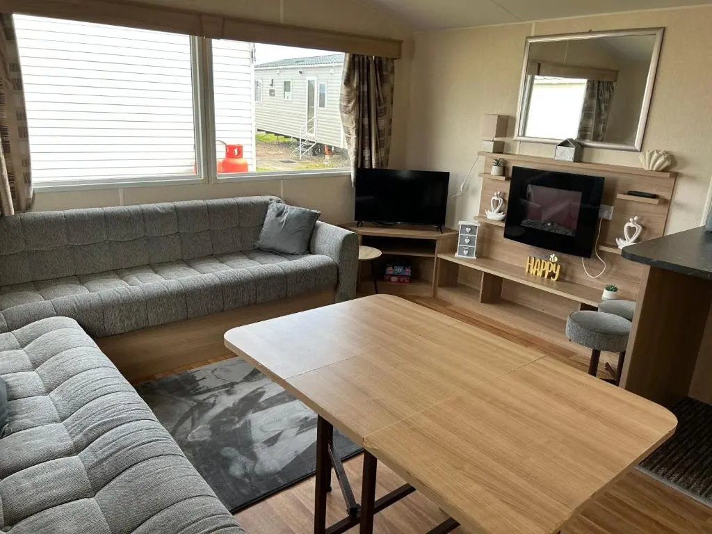 a living room with a couch and a table at A13 - Beach Haven at Silversands in Lossiemouth