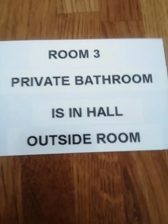a sign that reads room private bathroom is in hall outside room at Gladstone Cottage in Inverness