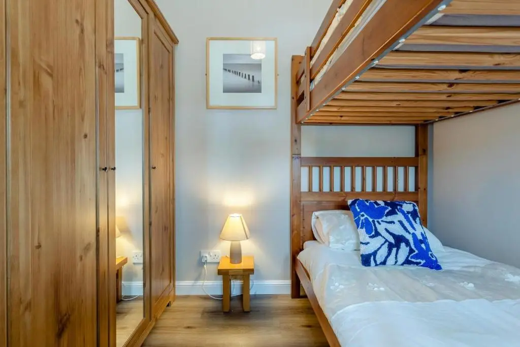 a bedroom with a wooden bunk bed with a staircase at 2 Bed in Cromarty oc-s32047 in Cromarty