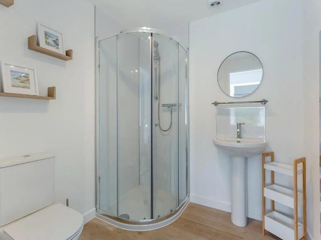 a bathroom with a glass shower and a sink at Ferry Cottage in Eskadale