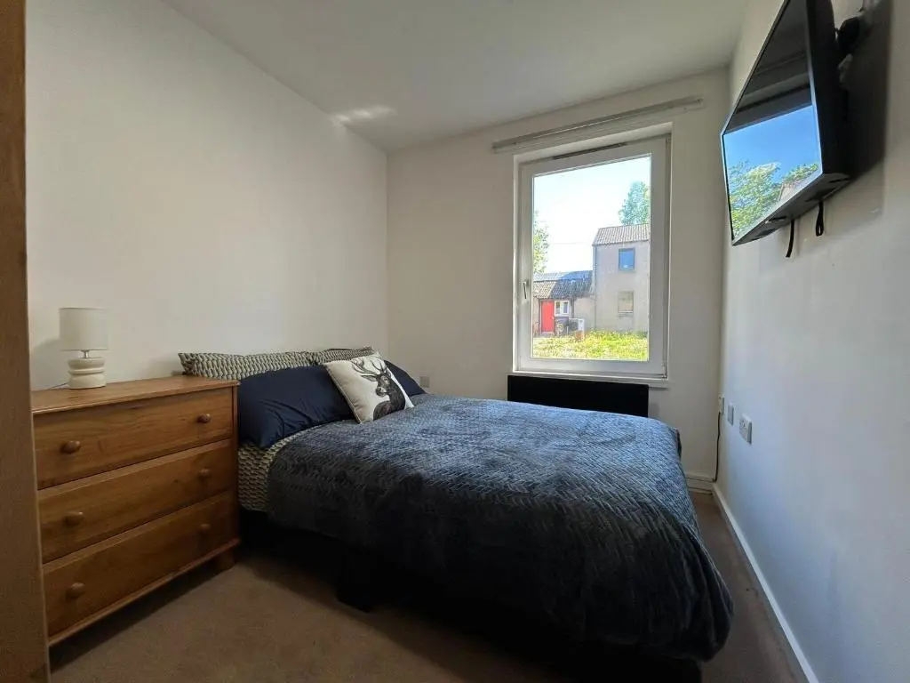 a bedroom with a bed and a dresser and a window at Two bedroom cottage in Lumsden - Contractors in Huntly