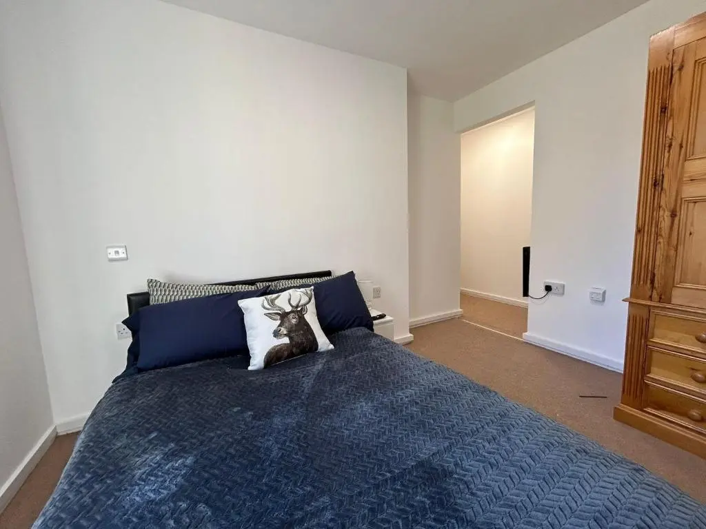 a bedroom with a bed with a blue comforter at Two bedroom cottage in Lumsden - Contractors in Huntly