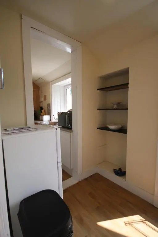 a room with a refrigerator and a kitchen with a window at Stag View in Garve