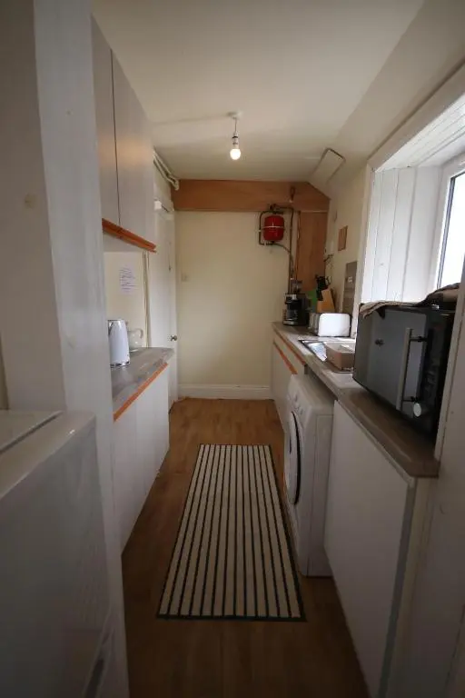 a small kitchen with a washing machine and a microwave at Stag View in Garve