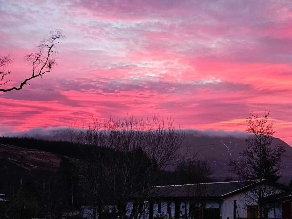 a sunset with a pink in the sky at Stag View in Garve