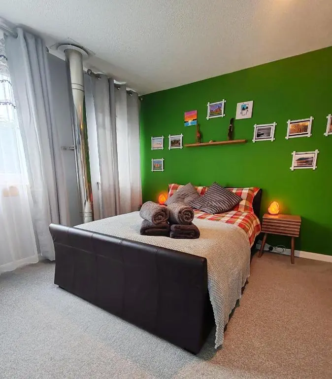 a green bedroom with a bed with towels on it at Private Holiday Home in Inverness with Free Parking l Sleeps 4 in Dalneigh