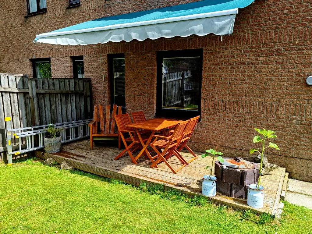 a wooden deck with two chairs and a table at Private Holiday Home in Inverness with Free Parking l Sleeps 4 in Dalneigh