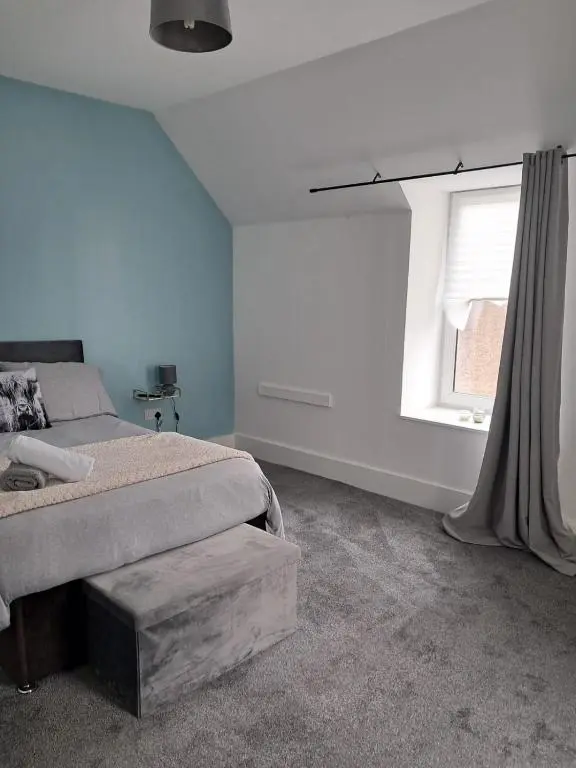 a bedroom with a bed and a window at Granny's Hoose in Wick