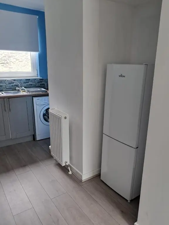 a kitchen with a white refrigerator and a sink at Granny's Hoose in Wick