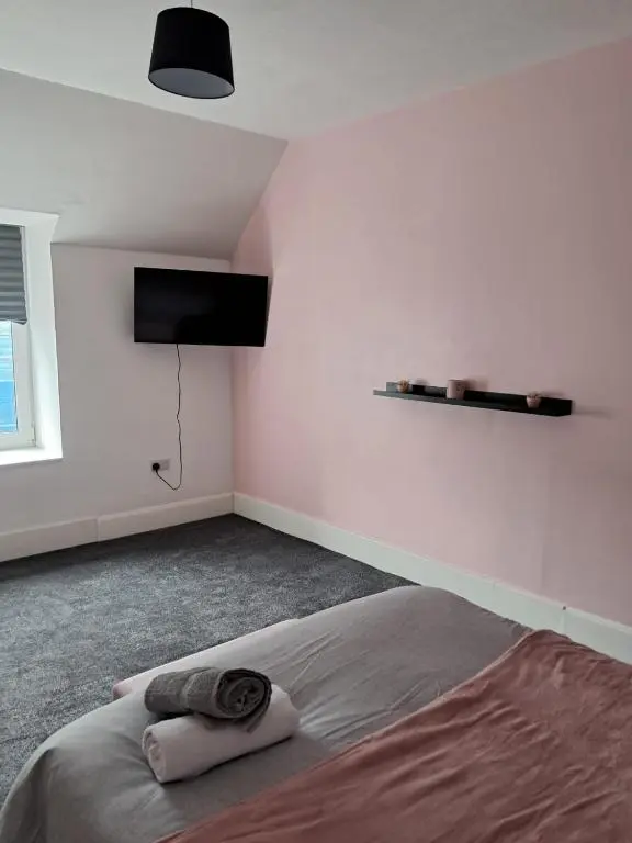 a bedroom with a bed and a flat screen tv at Granny's Hoose in Wick