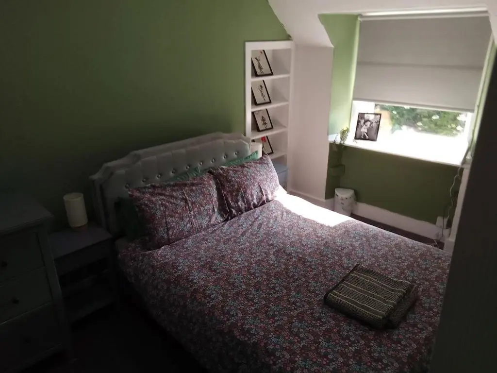 a bedroom with a large bed with a window at Cosy Crown 1 bedroom flat for up to 4 guests in Inverness