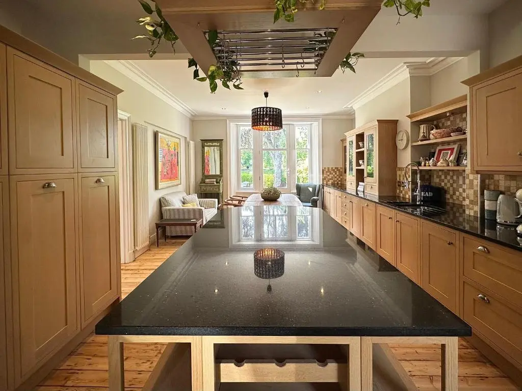 a large kitchen with a large black counter top at Ladies Walk - Stunning Riverfront Home in Inverness
