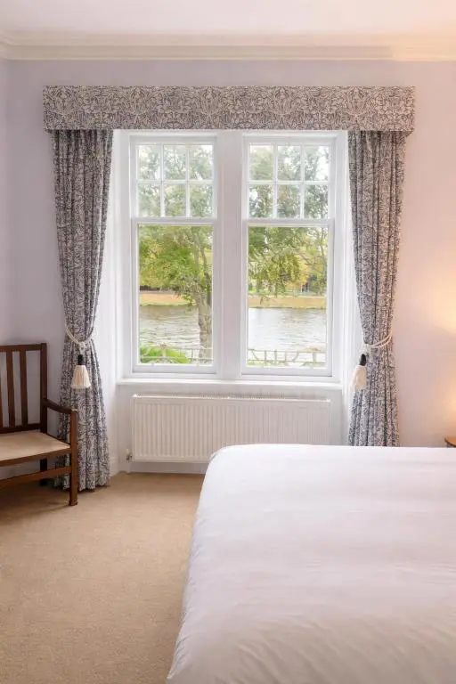 a bedroom with a bed and a large window at Ladies Walk - Stunning Riverfront Home in Inverness