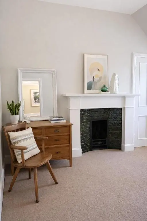 a living room with a chair and a fireplace at Ladies Walk - Stunning Riverfront Home in Inverness