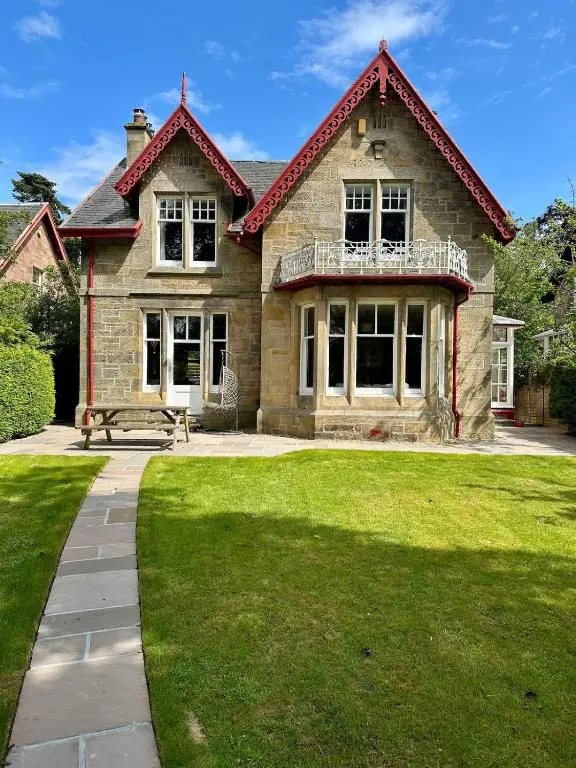a large brick house with a lawn in front of it at Ladies Walk - Stunning Riverfront Home in Inverness